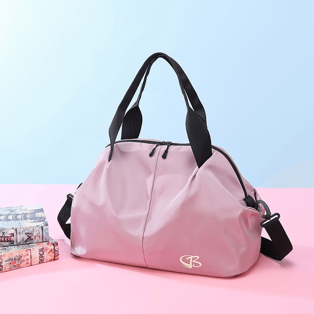 Pink waterproof women's gym bag with black handles on a pink surface, ideal for sports and travel. Large capacity, stylish design.
